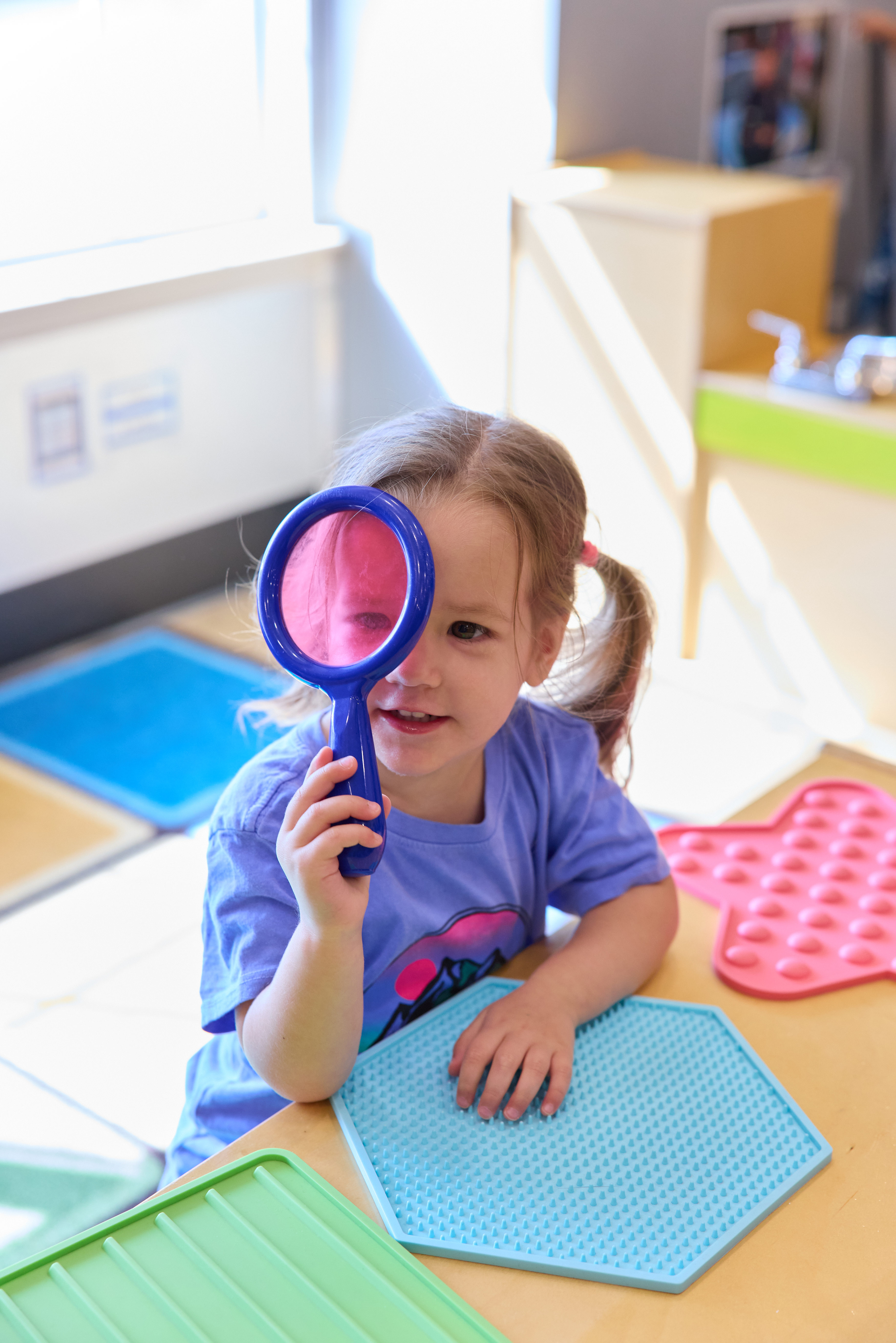 Teacher reading a book with preschool children gathered on a classroom rug