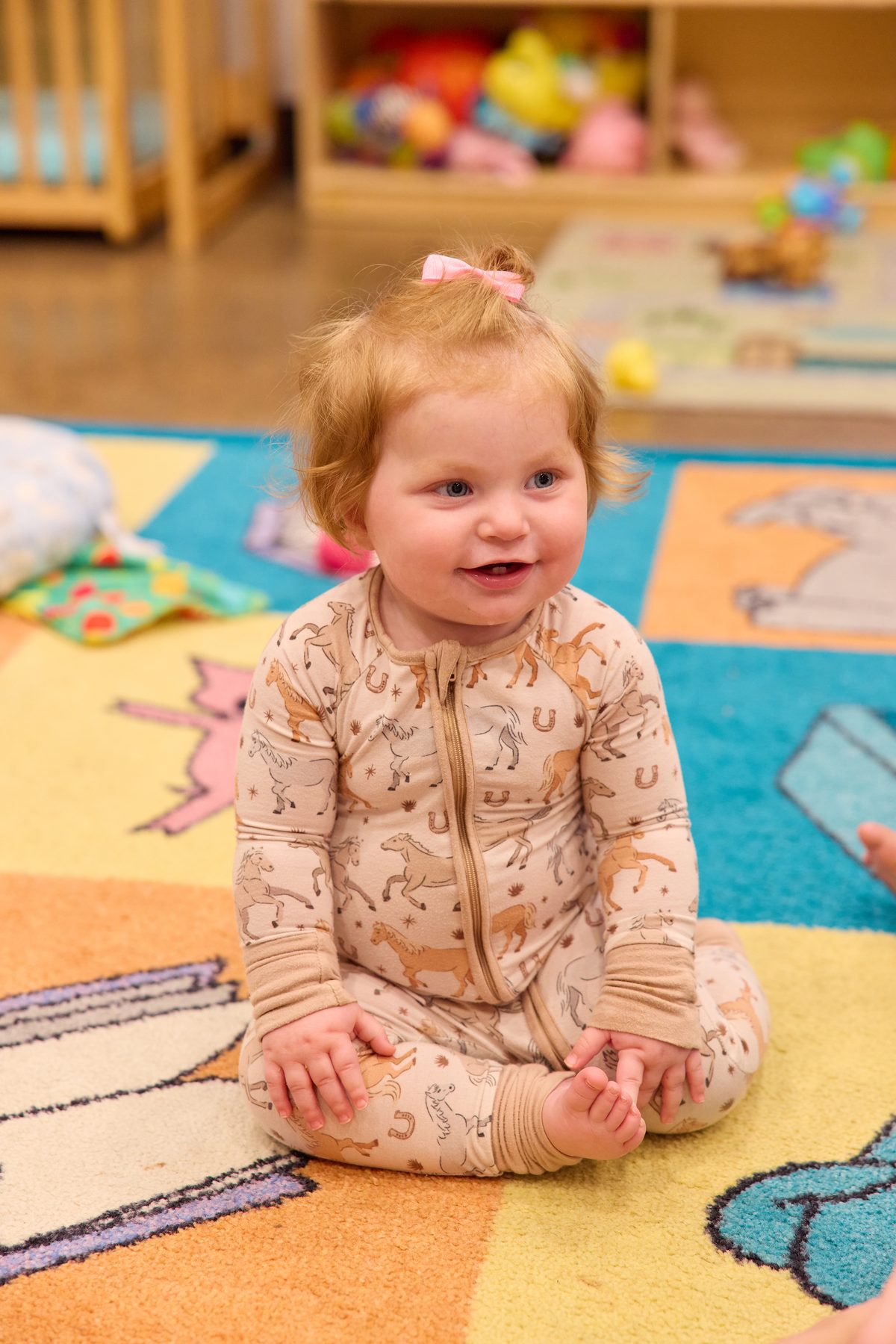 Teacher reading a book with preschool children gathered on a classroom rug